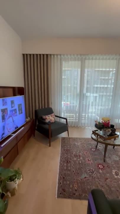 Salonda dalga model tül perde, koltuk ve TV ünitesi